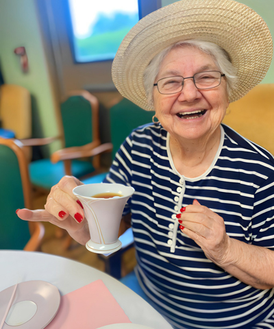 Senior woman smiling and enjoying a cup of tea.